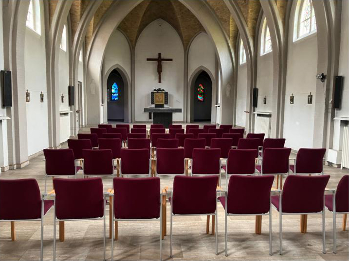 Interieur van de kapel van het Patersklooster in Asten, met stoelen opgesteld voor de lezing